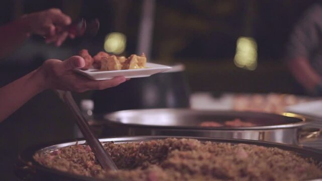 persona tomando alimentos de un bufet en un restaurant