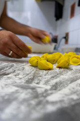The preparation of homemade tortellini filled with ricotta and spinach