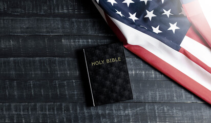 United States of America flag. Black Bible book on wooden background. Constitution.