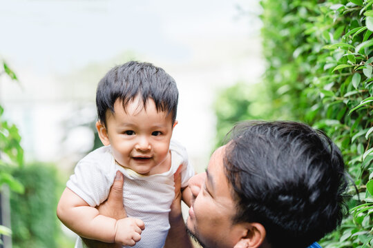 Asian Father day.father and baby son on the park in summer.Smile child and dad happy together.Father and kid baby kiss and hug with love. Family dad day.People having fun outdoor.friendly family.