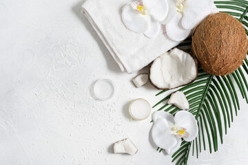 Coconut cream in a jar on a white table next to the coconut slices