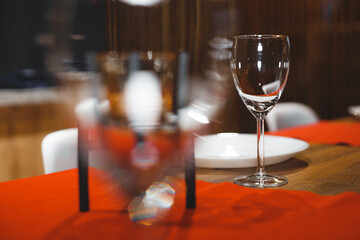 Empty table with red tablecloth served for reception of guests for dinner