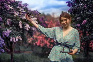 Attractive girl in a turquoise dress launches a drone.