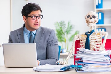 Businessman working with skeleton in office