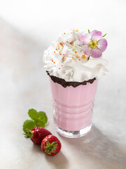 Cold strawberry milkshake, with fresh strawberries and cream. Healthy food for breakfast and snack.