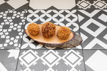 Typical Spanish tapa of round croquettes on wooden plate