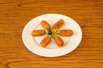 Typical Spanish tapa of ham croquettes with a little bit of garnish in the center