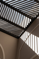 Obraz premium Modern east style building with beige walls and rail sunlight shadows on walls. Aesthetic abstract minimal architecture facade design