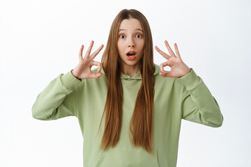 Impressed teen girl gasp and show okay sign, praise something impressive, compliment amazing event,...