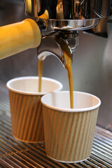 cafés expresos en cafetera de cafetería con vasos reciclables