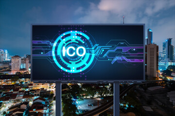 ICO hologram icon on billboard over panorama city view of Kuala Lumpur at night. KL is the hub of blockchain projects in Malaysia, Asia. The concept of initial coin offering, decentralized finance
