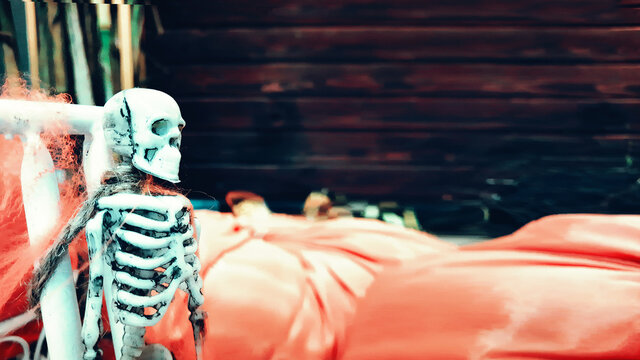 Creepy background for Halloween with toy white skeleton for decoration. ?orror concept - white toy skull on artificial cobweb. Halloween concept.