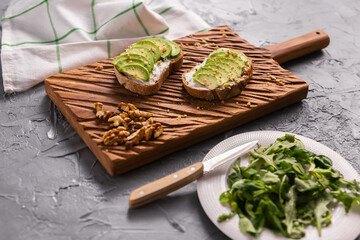 Fototapeta na wymiar Avocado sandwich on dark rye bread made with fresh sliced avocados from above. Breakfast concept.
