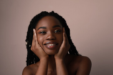 Smiling young black woman posing in the studio. Isolated closeup portrait.