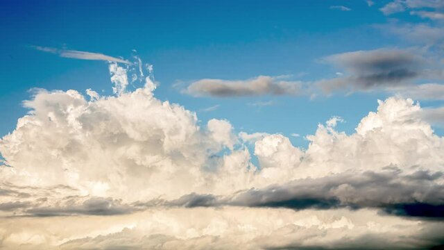 White clouds formed and condensed into rain clouds, the background was the blue sky in the afternoon, the clouds moved quickly