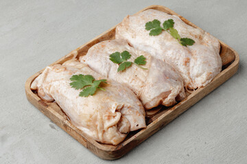Raw chicken carcass on wooden plate close up