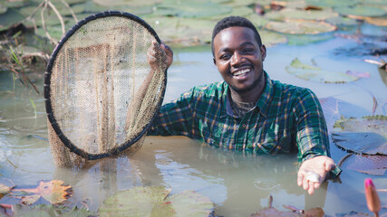 African farmer carry nets used to catch fish on his farms.Agriculture or cultivation concept