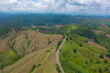 Aerial view of cars driving on curved, zigzag curve road or street on mountain hill with green...