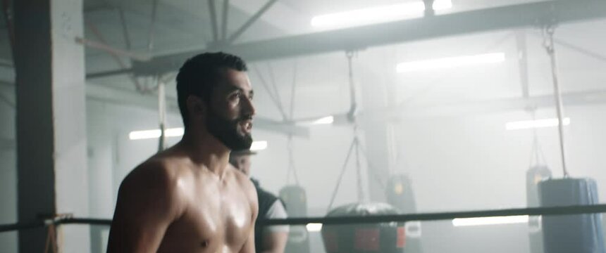 HANDHELD Two fighters greeting each other before fighting, boxing sparring match, trainers watching in the background. Dynamic cinematic footage. Shot with 2x anamorphic lens