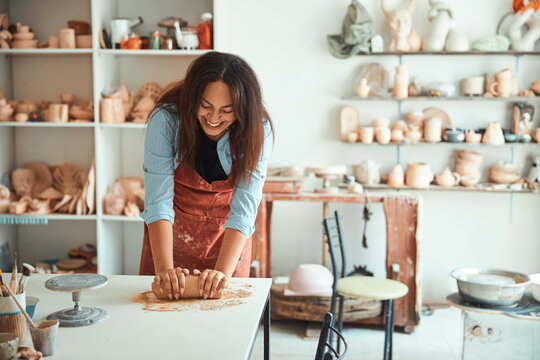 Cheerful Young Woman Working In Pottery Workshop