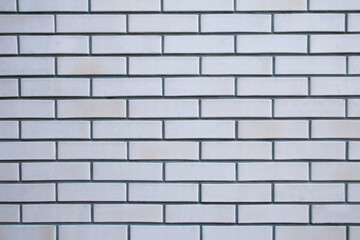 Frontal view of a wall of gray bricks. Imitation brick and wall cladding. Texture; background.