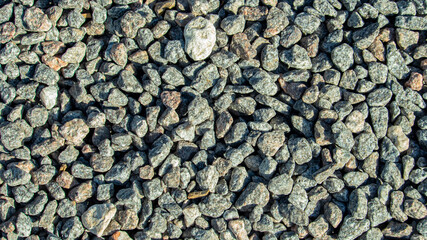 small granite stones on the beach, on a sunny day, backgrounds, textures