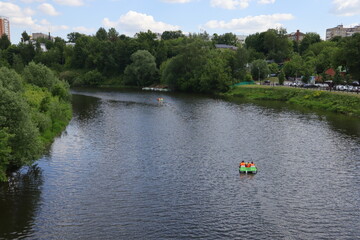 family rides on the river on a catamaran on a summer day, top view from afar