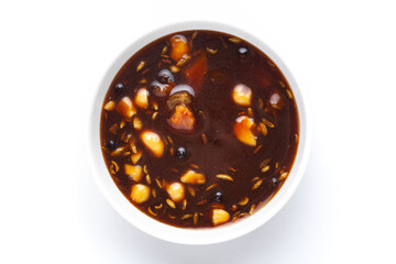 Close-up of mango dry fruits sweet red dark chutney used in Indian chaat and fast food in white ceramic bowl.