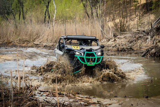 Cool view of active 4x4 vehicle driving in mud and water. ATV rider
