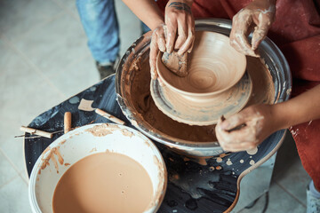 Potter hands polishing clay bowl in workshop