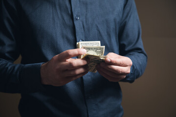 a man in a shirt counts the money