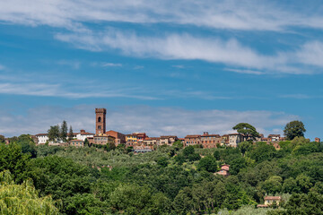 Panoramic view of the ancient Tuscan village of Montecarlo di Lucca, Italy, under a beautiful sky - obrazy, fototapety, plakaty