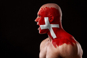 Switzerland fan. Soccer or football athlete with flag bodyart on face. Sport concept with copyspace.