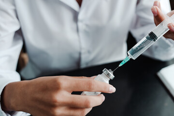 Close up photo. Female hands collect liquid with a syringe and are about to inject medicine