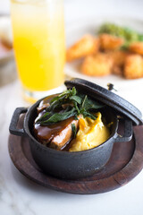 crock with mushed potatoes and meat