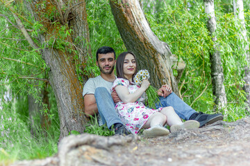 couple sitting on the grass in the park, happy couple having fun in the park