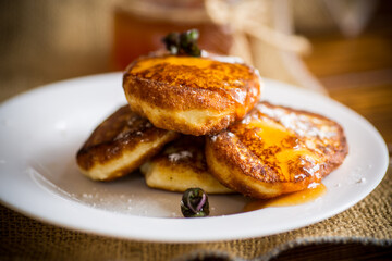sweet fried cottage cheese pancakes with jam in a plate