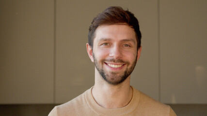 Young man looking at camera in home office. Young man looking at camera