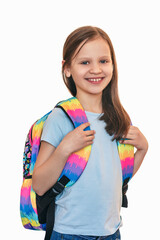 Girl with a backpack behind her back on a white background. The child goes to school with a colored backpack