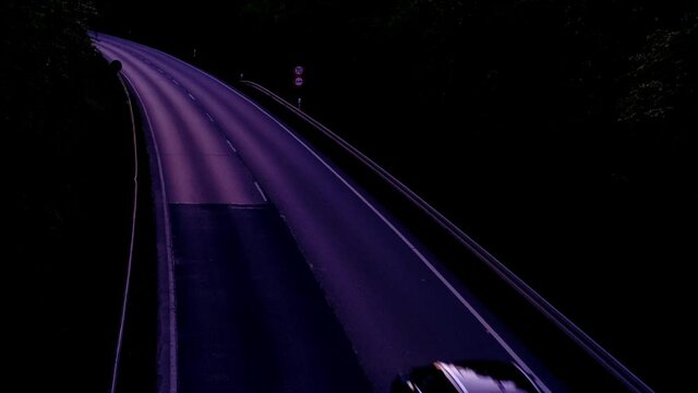 Traffic with motion cars with luminous lines of speed and the evening European city of Frankfurt with beautiful sunset sky, taunus mountains, cityscape