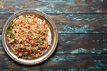 Middle eastern and Mediterranean traditional vegetable salad tabbouleh with couscous on rustic...