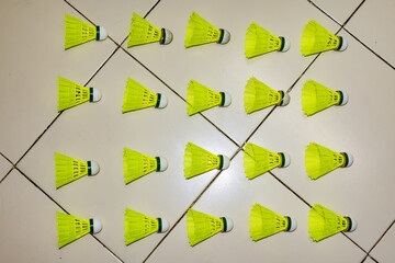 Nylon made yellow color badminton shuttlecock close view looking awesome placed on floor in different position. - 437109273