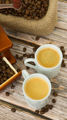Composition with coffee. Wooden coffee grinder, beans in a bag and two cups of freshly brewed coffee. Image with selective focus