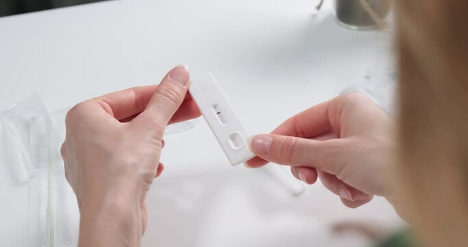 Over the shoulder view of person holding a negative self test of Covid-19, rapid antigen test for Coronavirus.