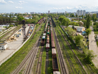 Obraz na płótnie Canvas Freight trains on railway tracks. Aerial drone view. Sunny spring day.