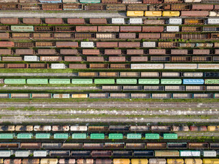 Freight trains on railway tracks. Aerial drone top view. Sunny spring day.