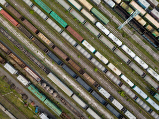 Freight trains on railway tracks. Aerial drone top view. Sunny spring day.
