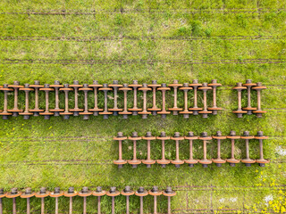 Wheels on railway tracks. Aerial drone top view. Green grass background.
