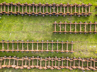 Wheels on railway tracks. Aerial drone top view. Green grass background.