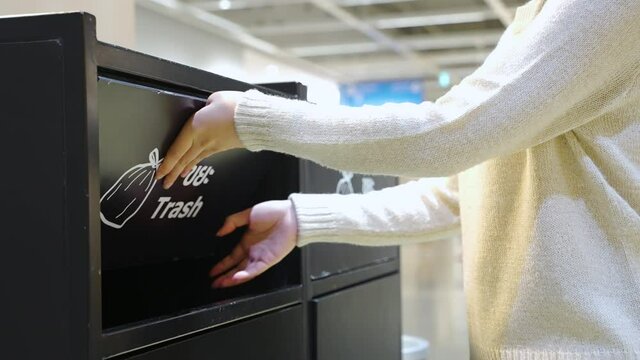 Unrecognized female throwing reused paper food containers into paper bin in the canteen. Concept of environment and save the world. slow-motion footage